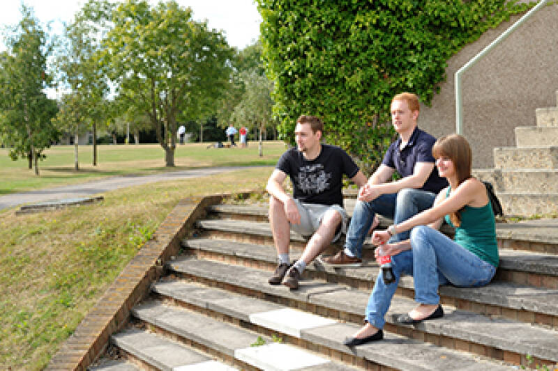 Students sitting on steps between Eliot and Becket